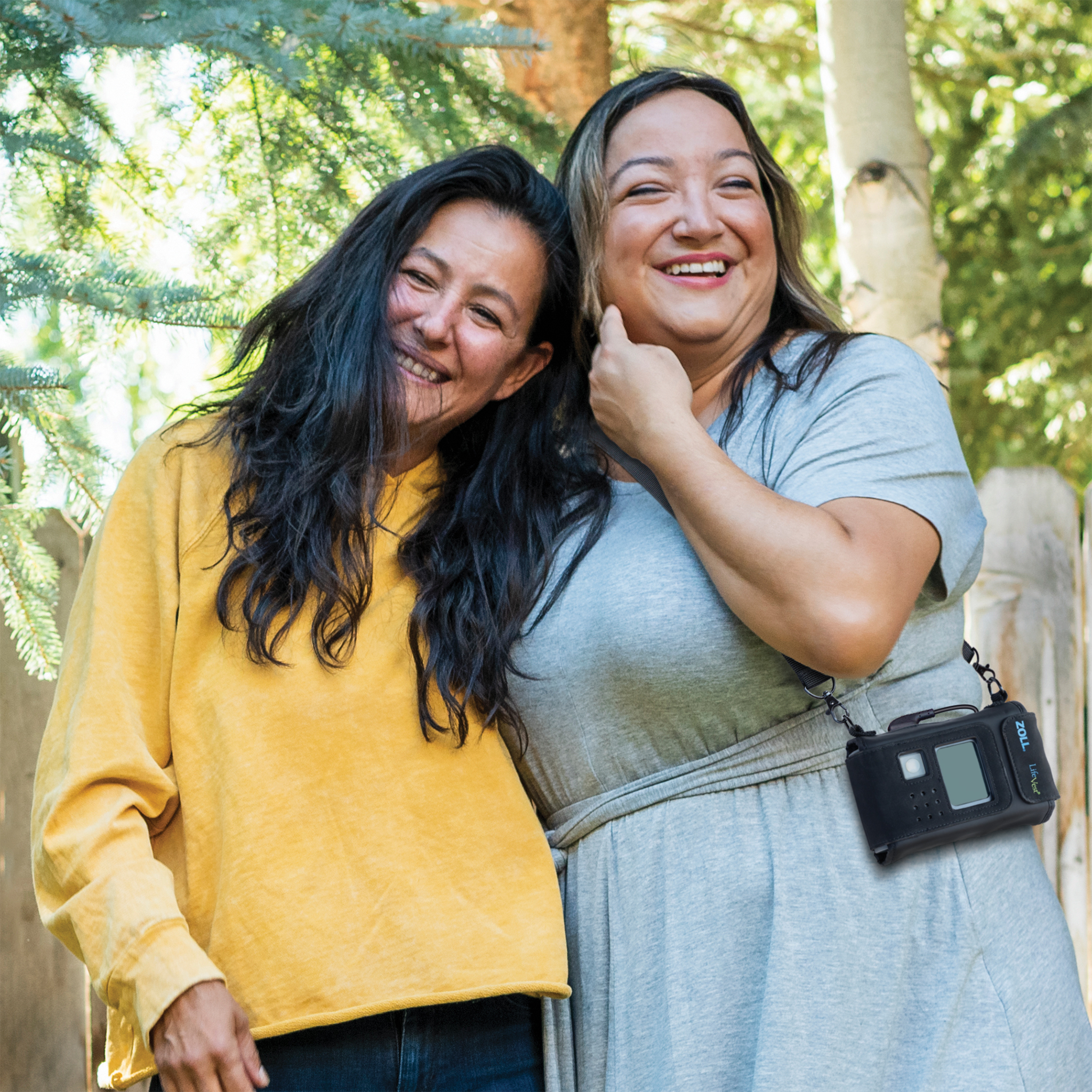 Two women facing camera, one with yellow shirt and one with blue dress and LifeVest