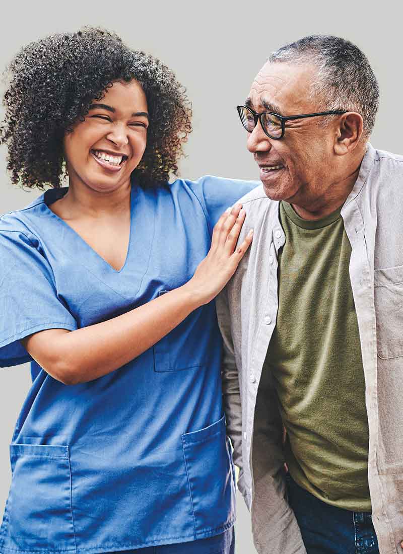 Image of medical professional and patient, both smiling. Medical professional has arm around patient.